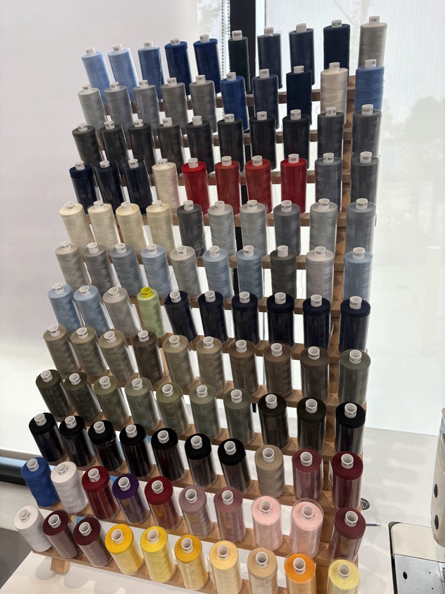 A wall of colour-graded thread spools inside the Craft Tailors studio on Fish Island